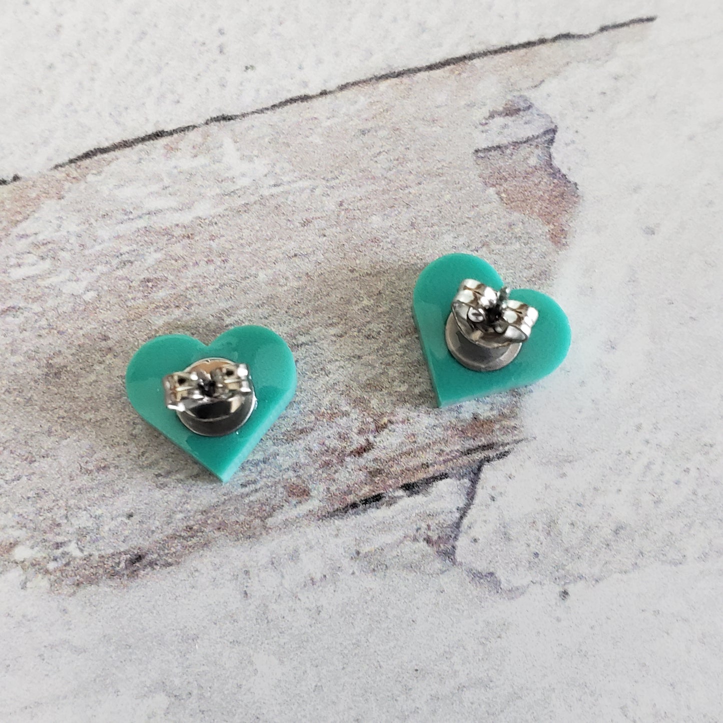 Backside of Matte mint green heart shaped stud earrings.