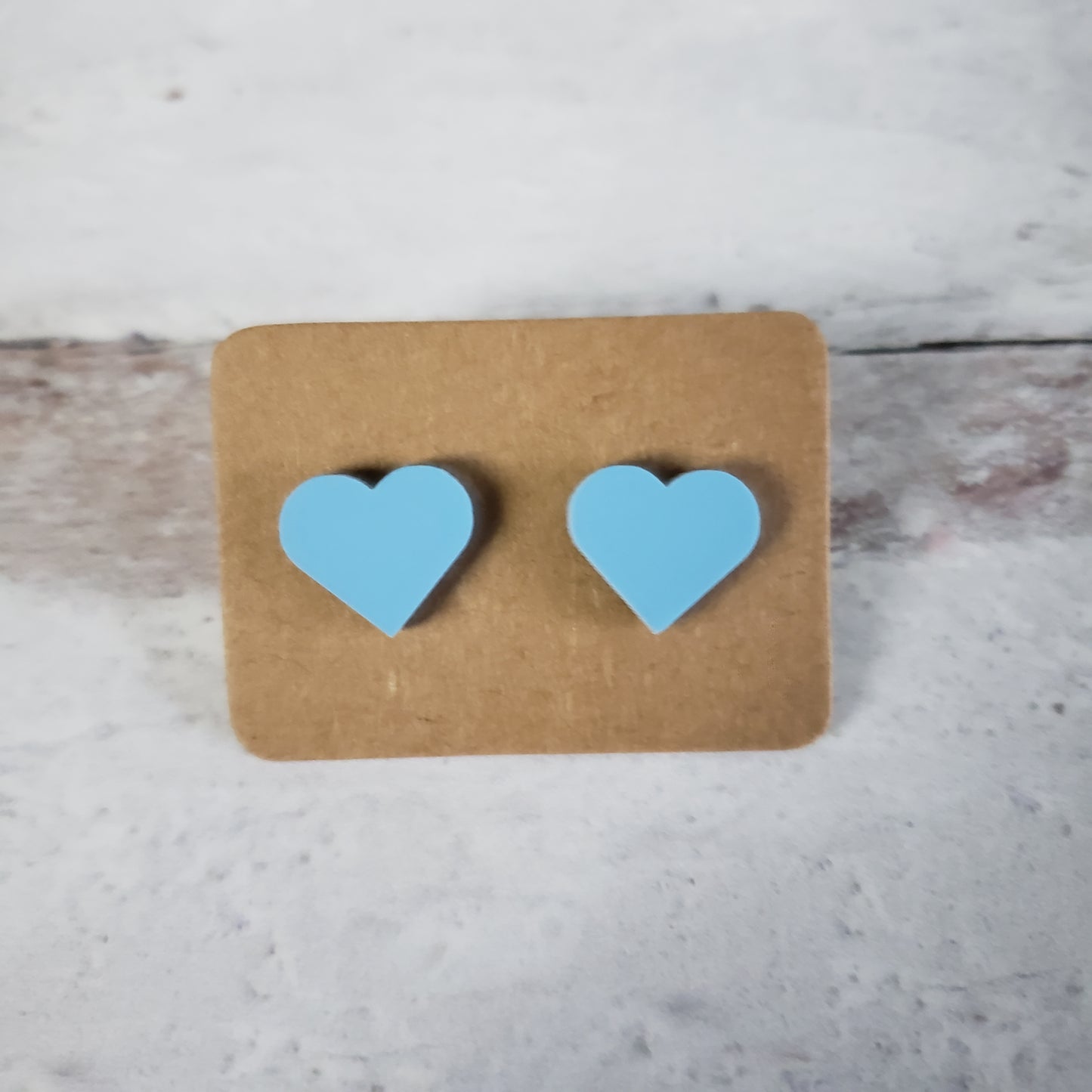 Matte pastel blue heart shaped stud earrings.