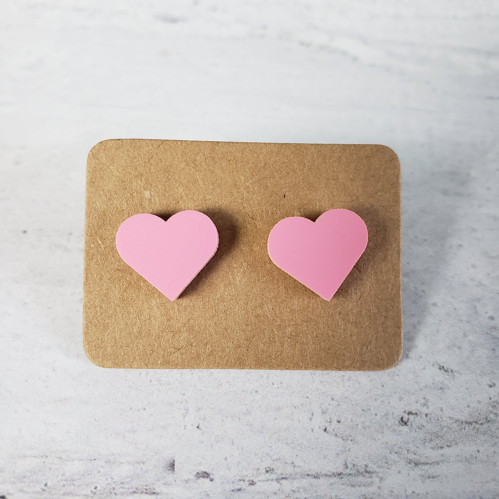 Matte pastel pink heart shaped stud earrings.