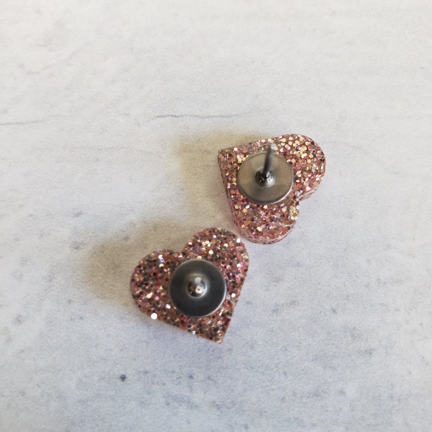 backside of rose gold glitter heart shaped stud earrings