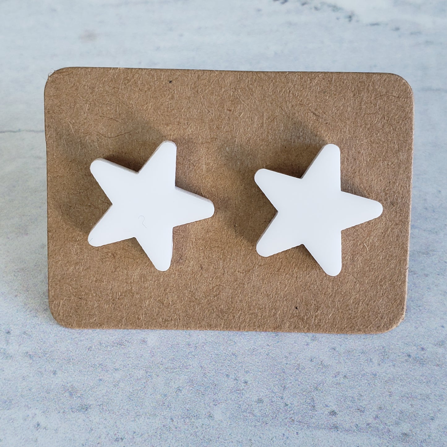White stud star earrings on earring card