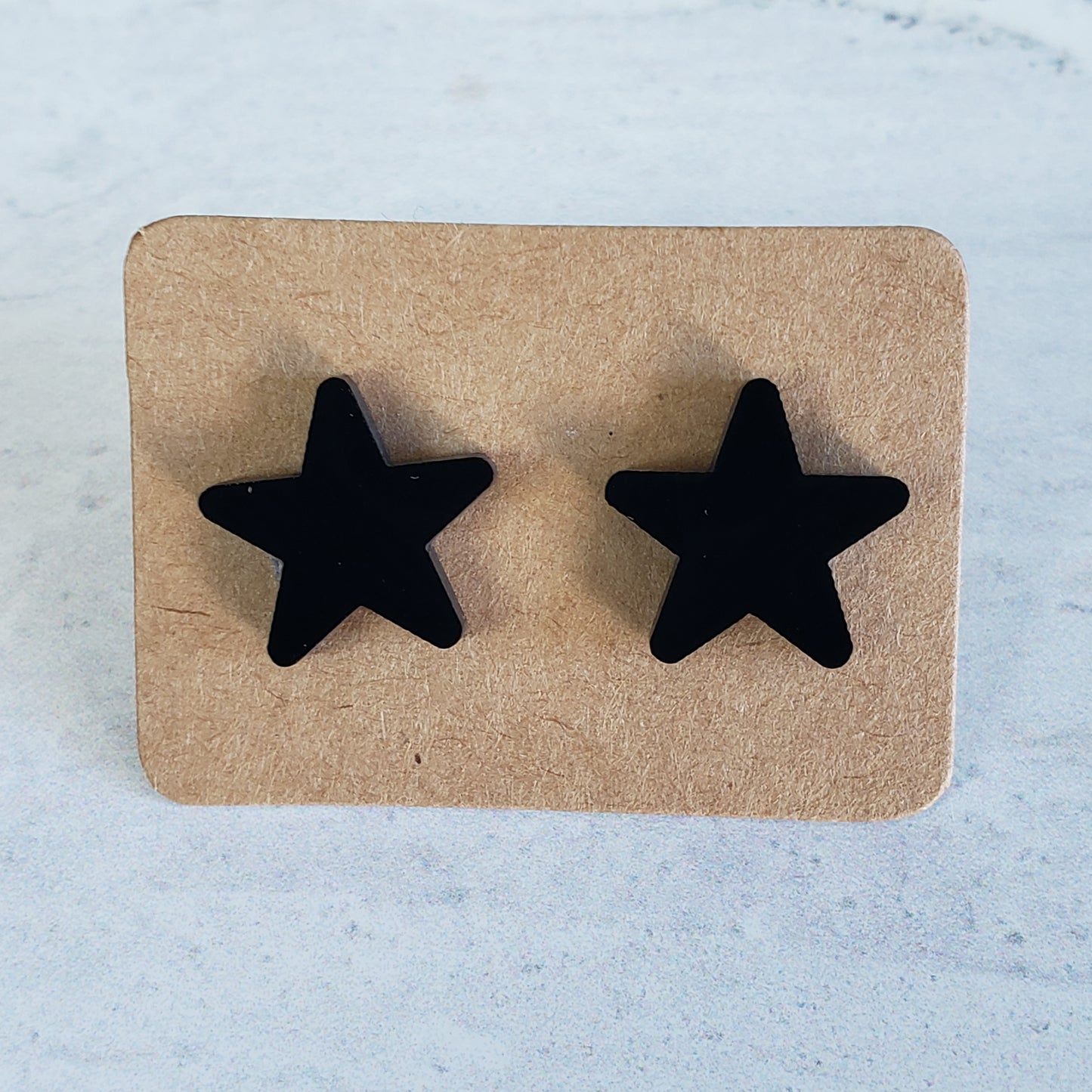 Black star stud earrings on earring card
