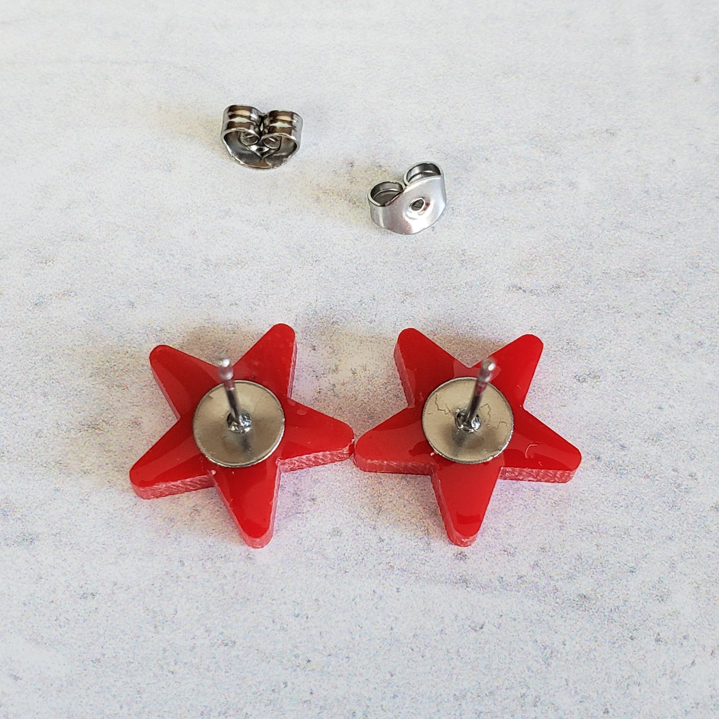 Backside of red star stud earrings showing posts