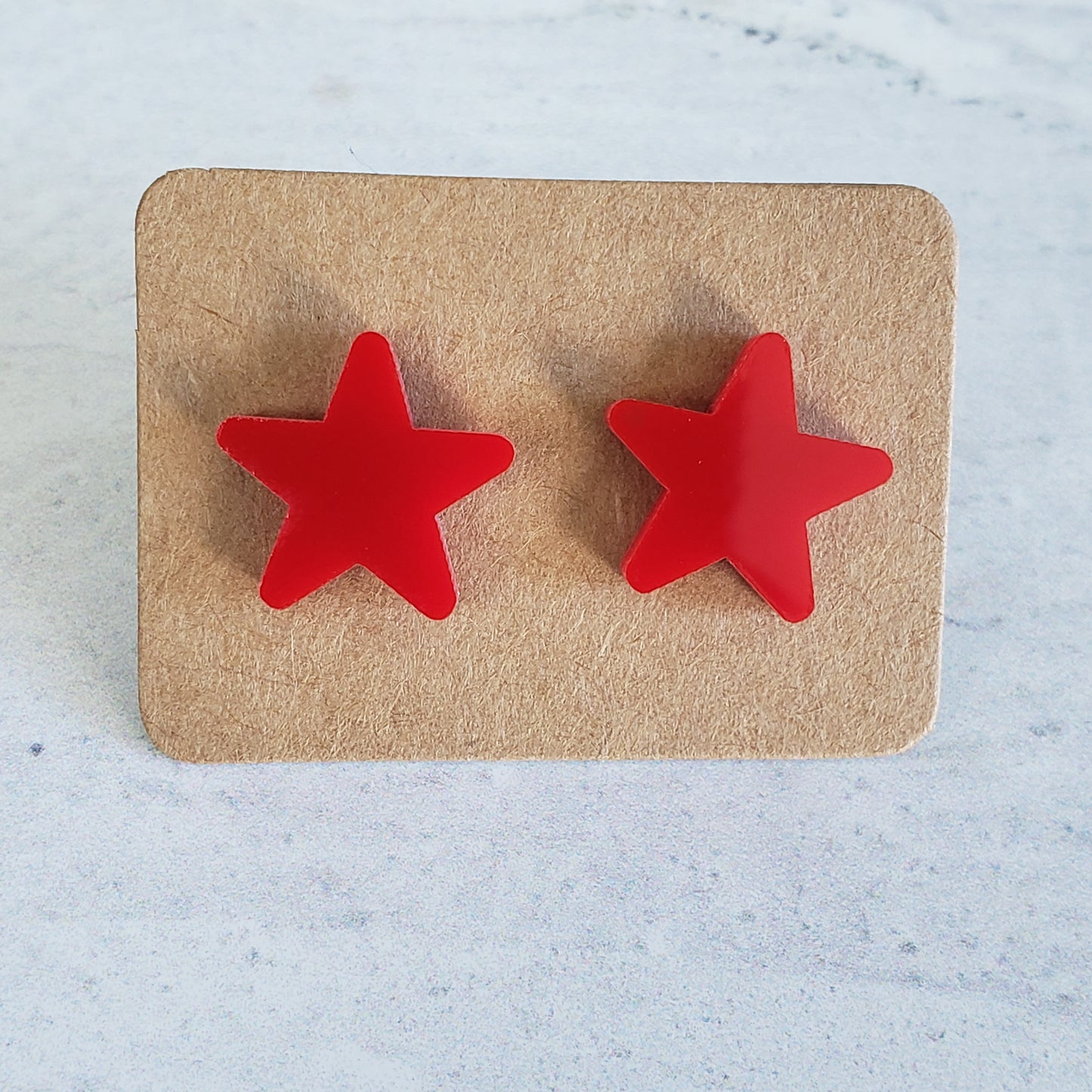 Red star stud earrings on earring card