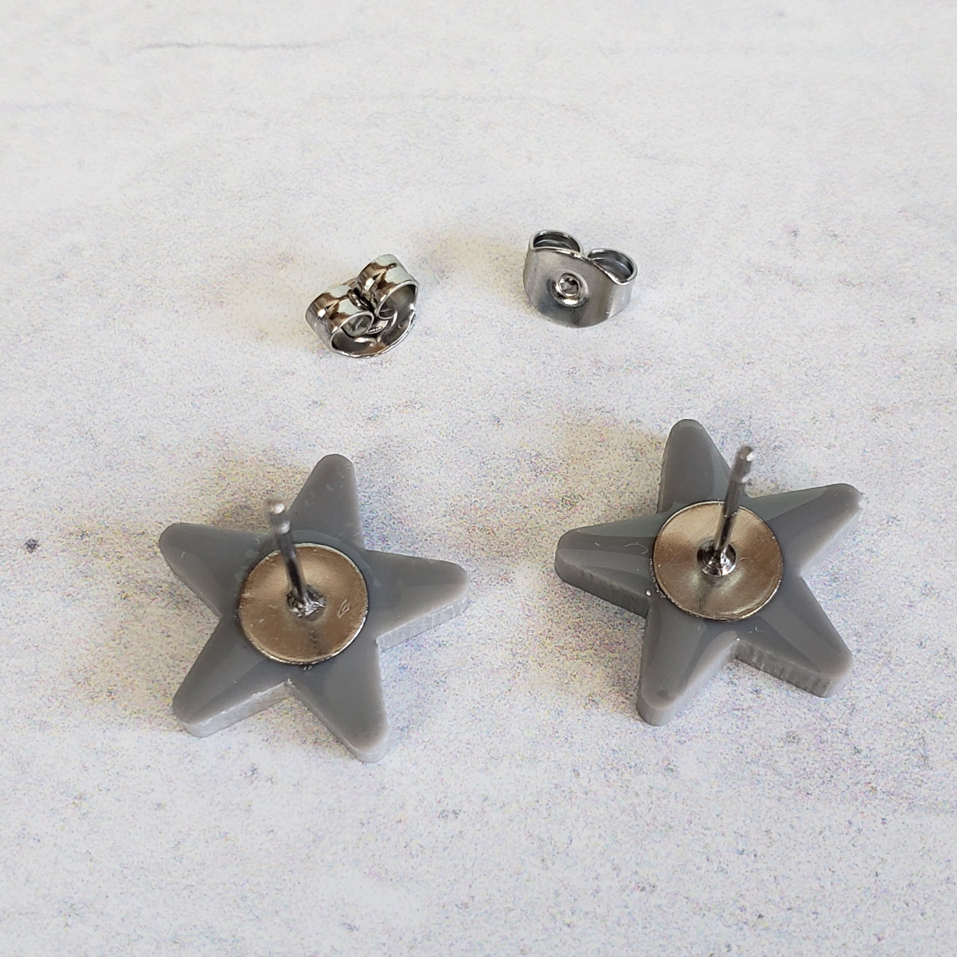 Backside of gray star stud earrings showing posts