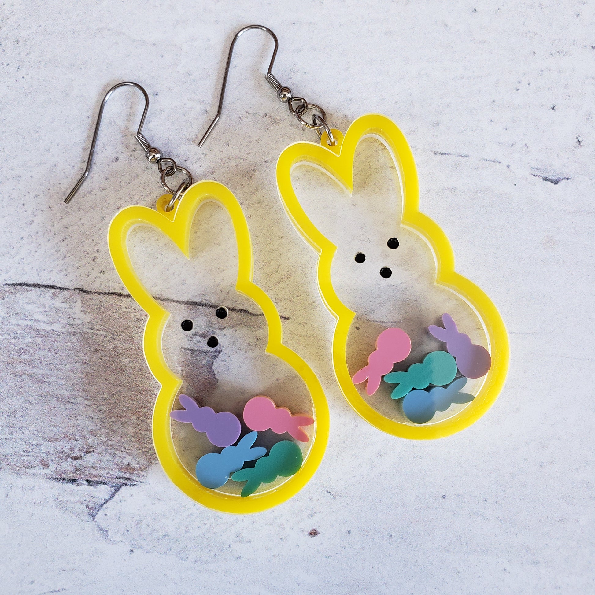 Marshmallow bunny shaker earrings in yellow with pastel bunnies inside on stainless steel earring wires.