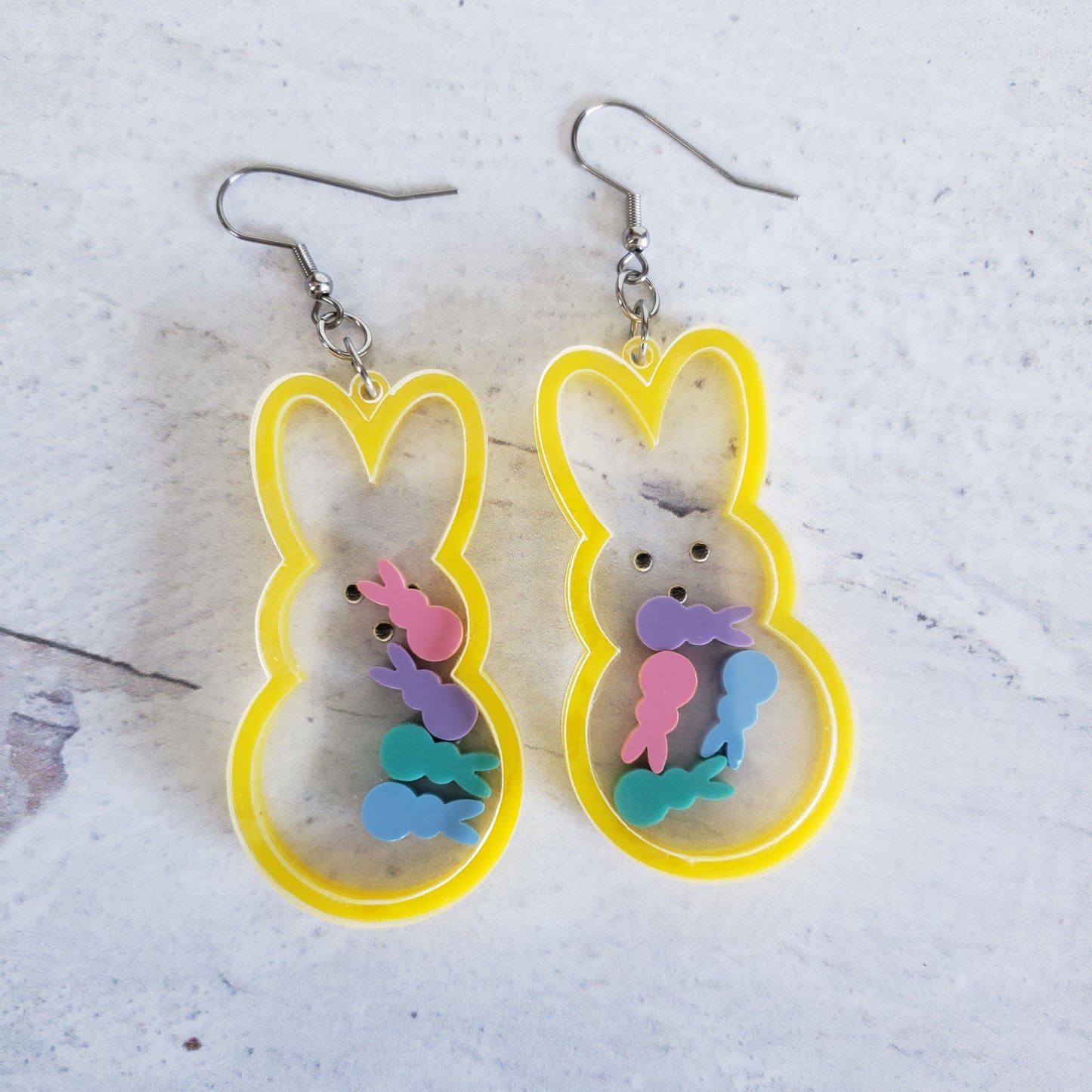 Marshmallow bunny shaker earrings in yellow with pastel bunnies inside on stainless steel earring wires.