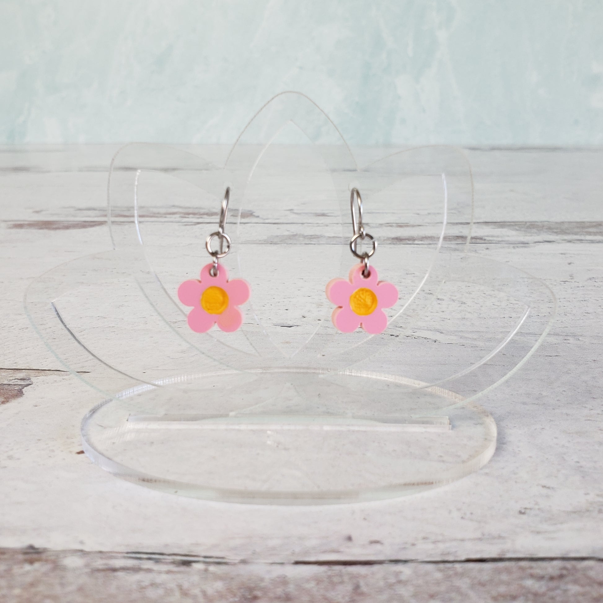 Pink daisy earrings on hanging display