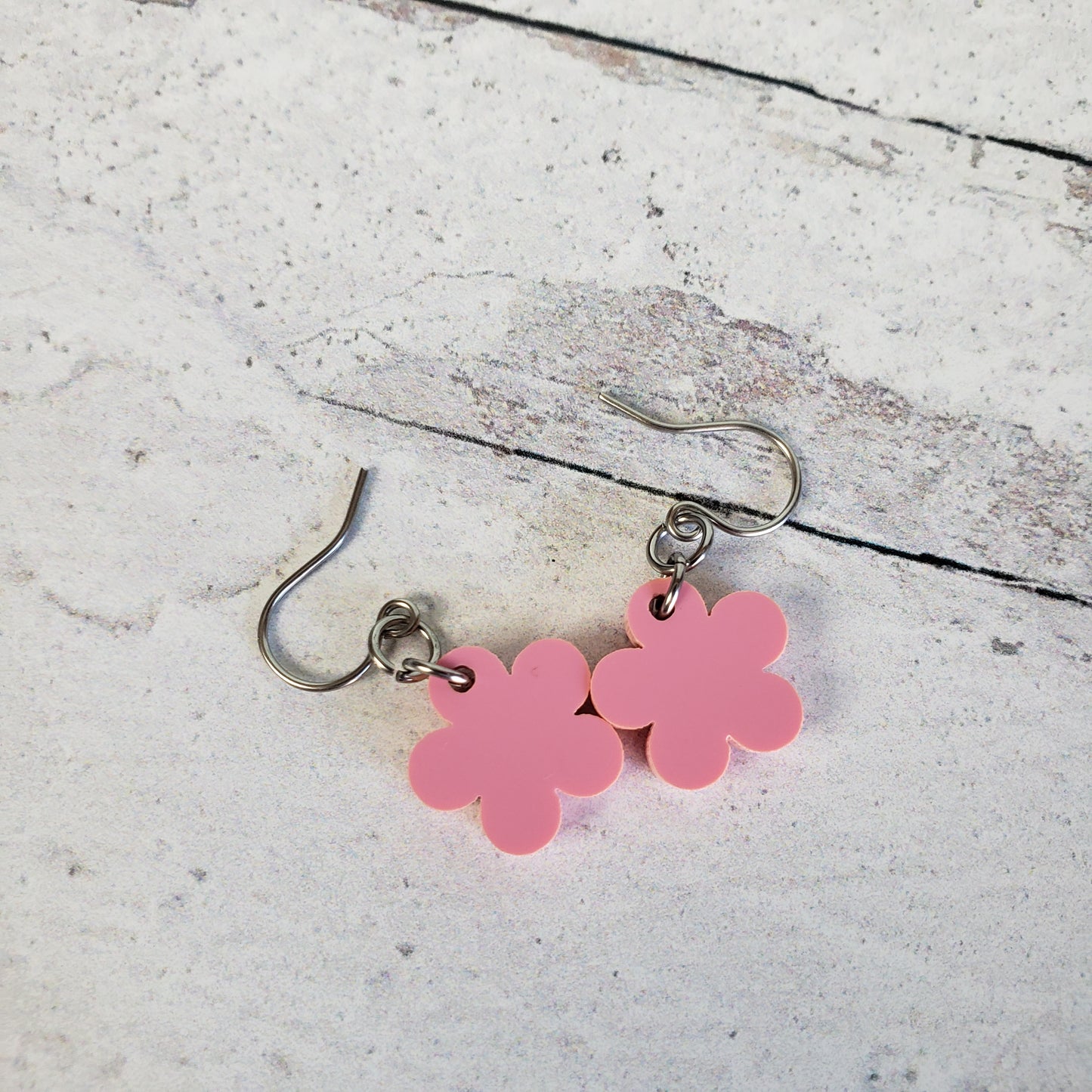 Backside of pink daisy earrings on stainless steel earring wires.