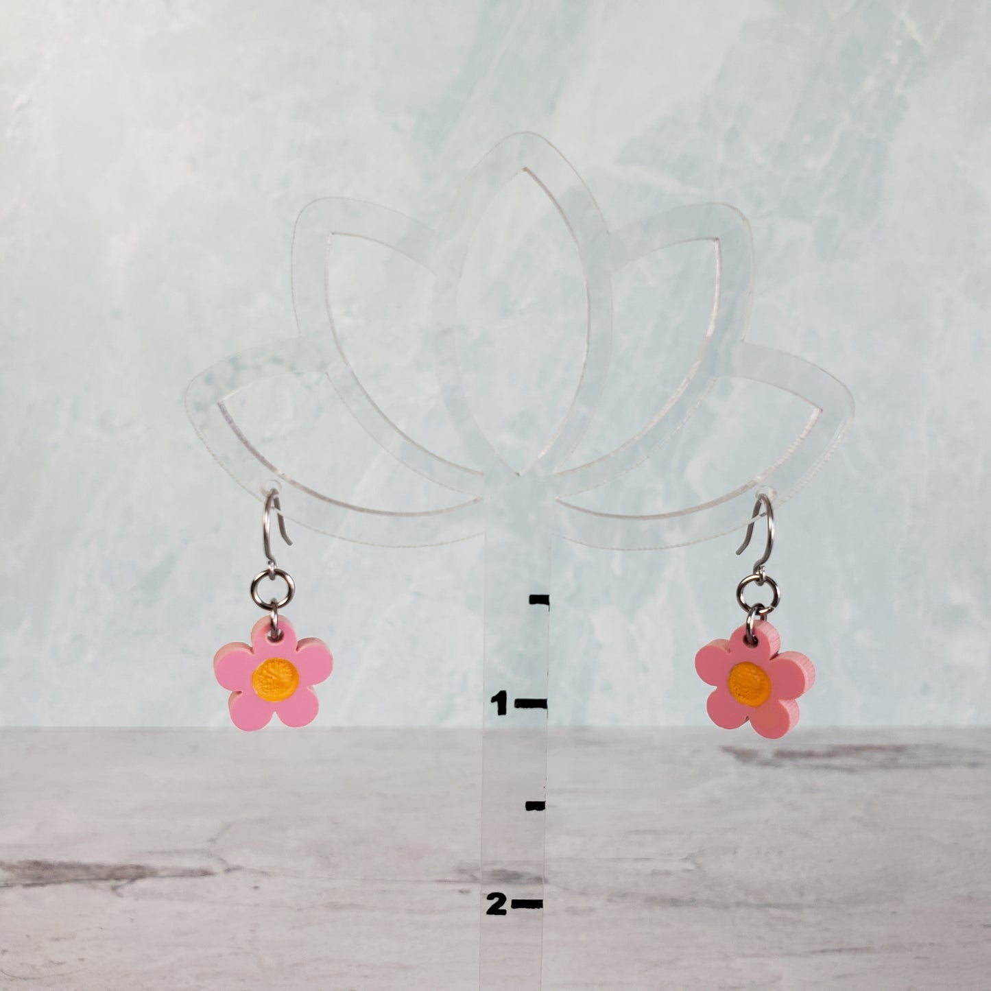 Pink daisy earrings on hanging display