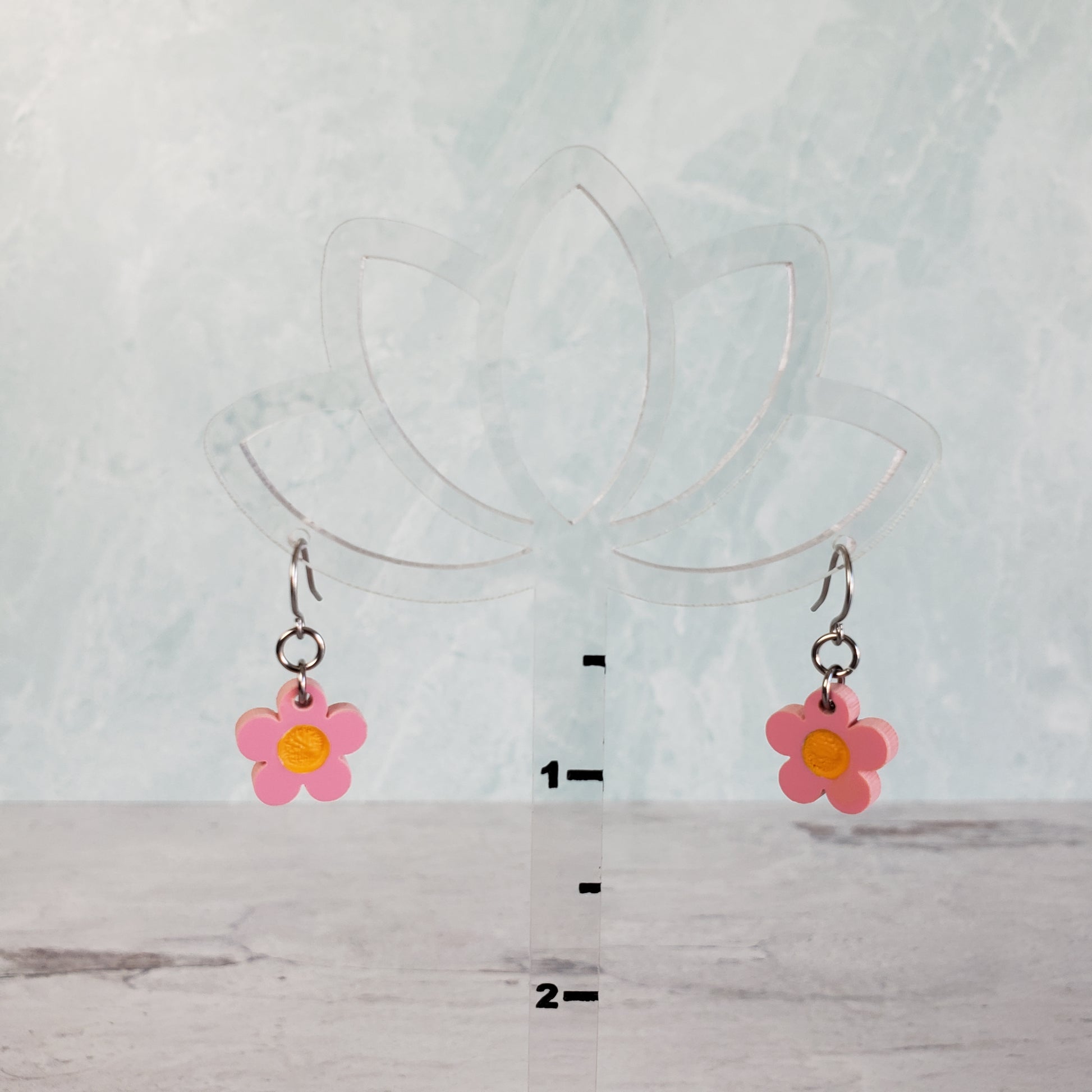 Pink daisy earrings on hanging display