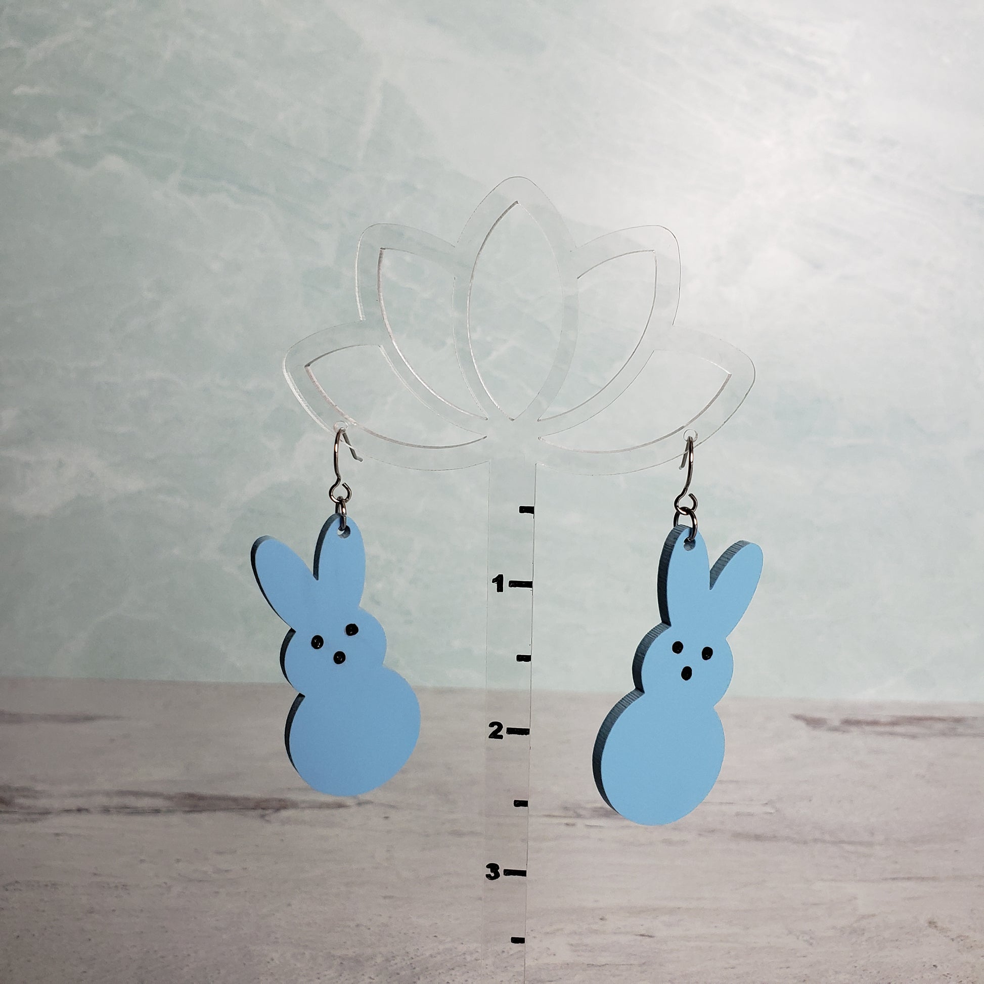 Matte pastel blue Marshmallow Bunny Earrings on stainless earring wires. on hanging display for size.