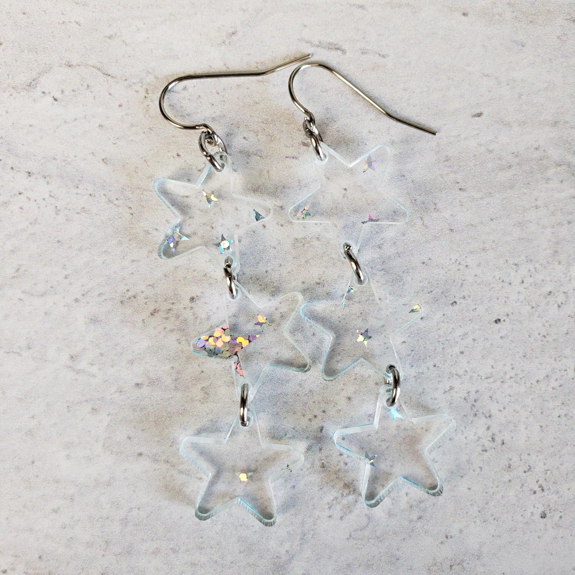 Clear star dangle earrings with holographic star print