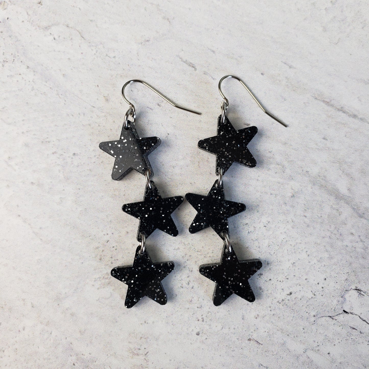 Black with silver glitter star dangle earrings on stainless steel earring wires