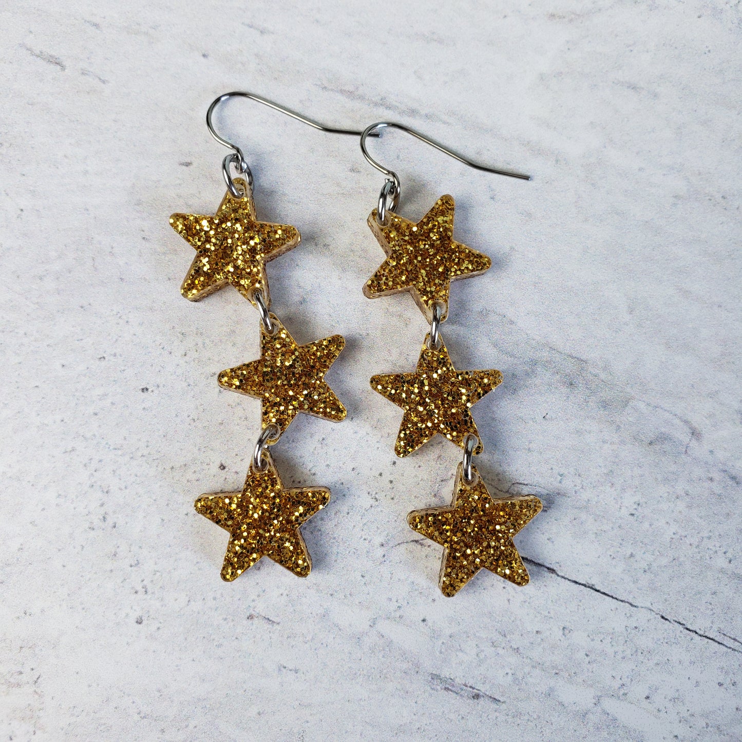 Gold tone glitter star dangle earrings on stainless steel earring wires