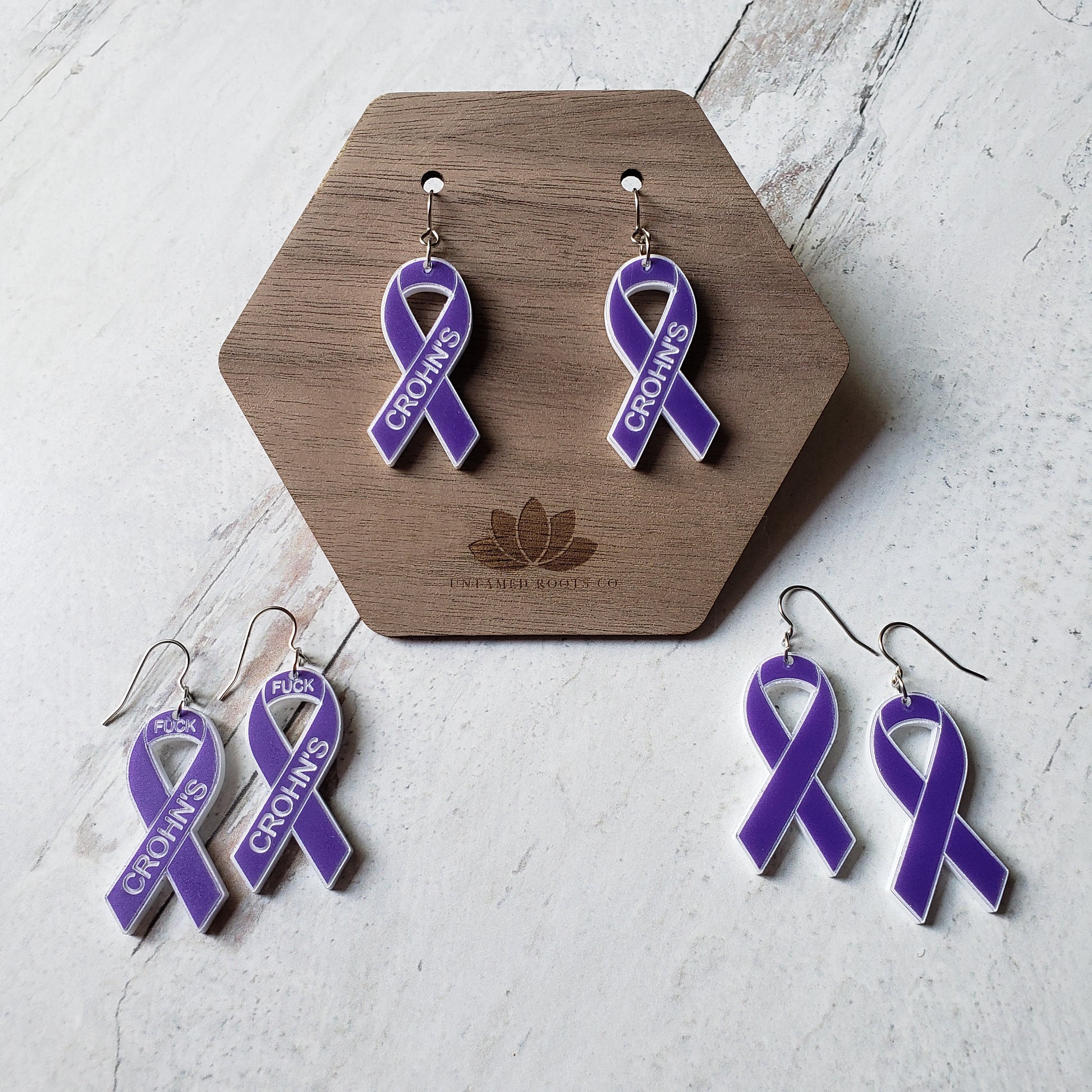 3 pairs of purple awareness ribbons, with engraving. Stainless steel earring wires.