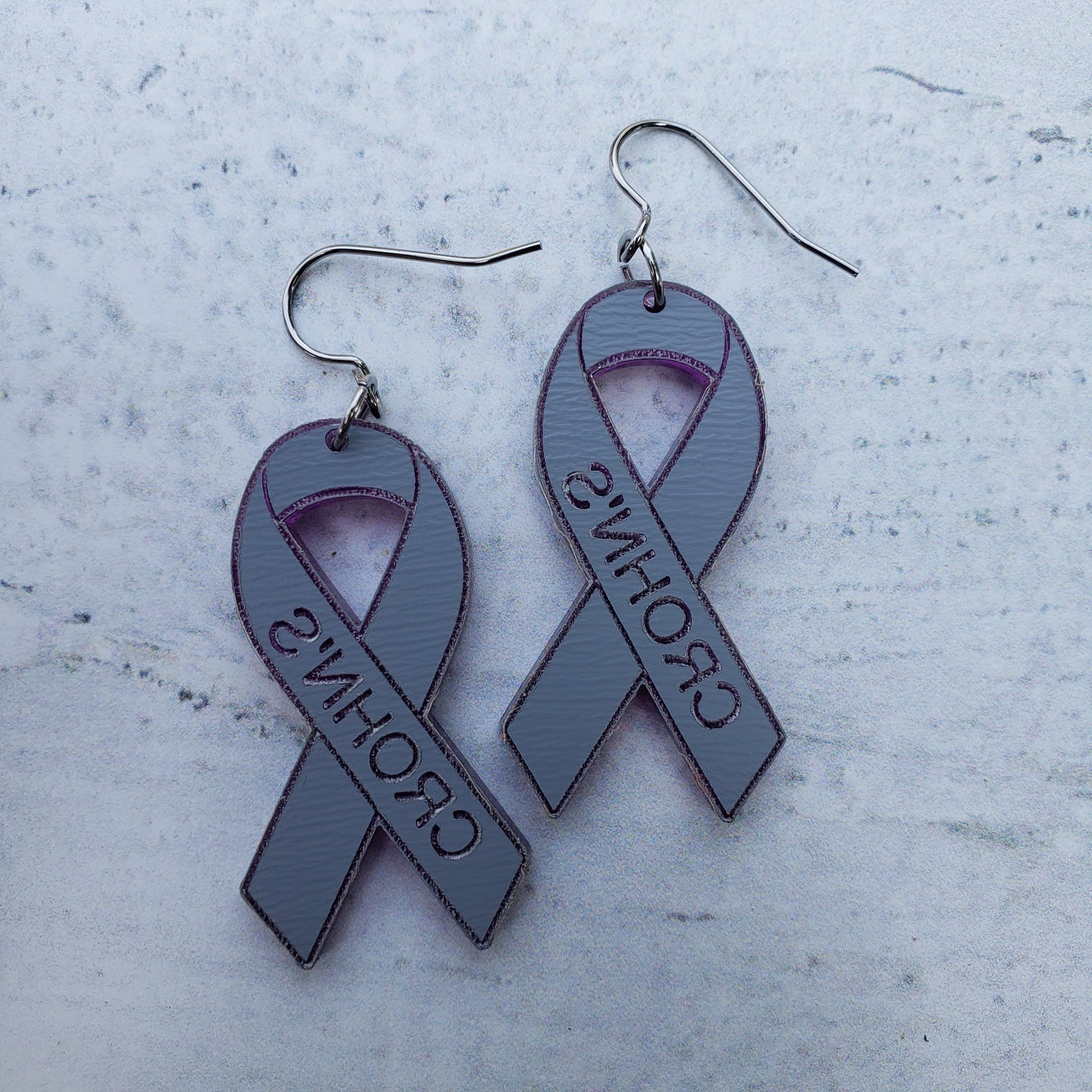 Backside of Crohn's Engraved purple mirror acrylic awareness ribbons on stainless steel earring wires.
