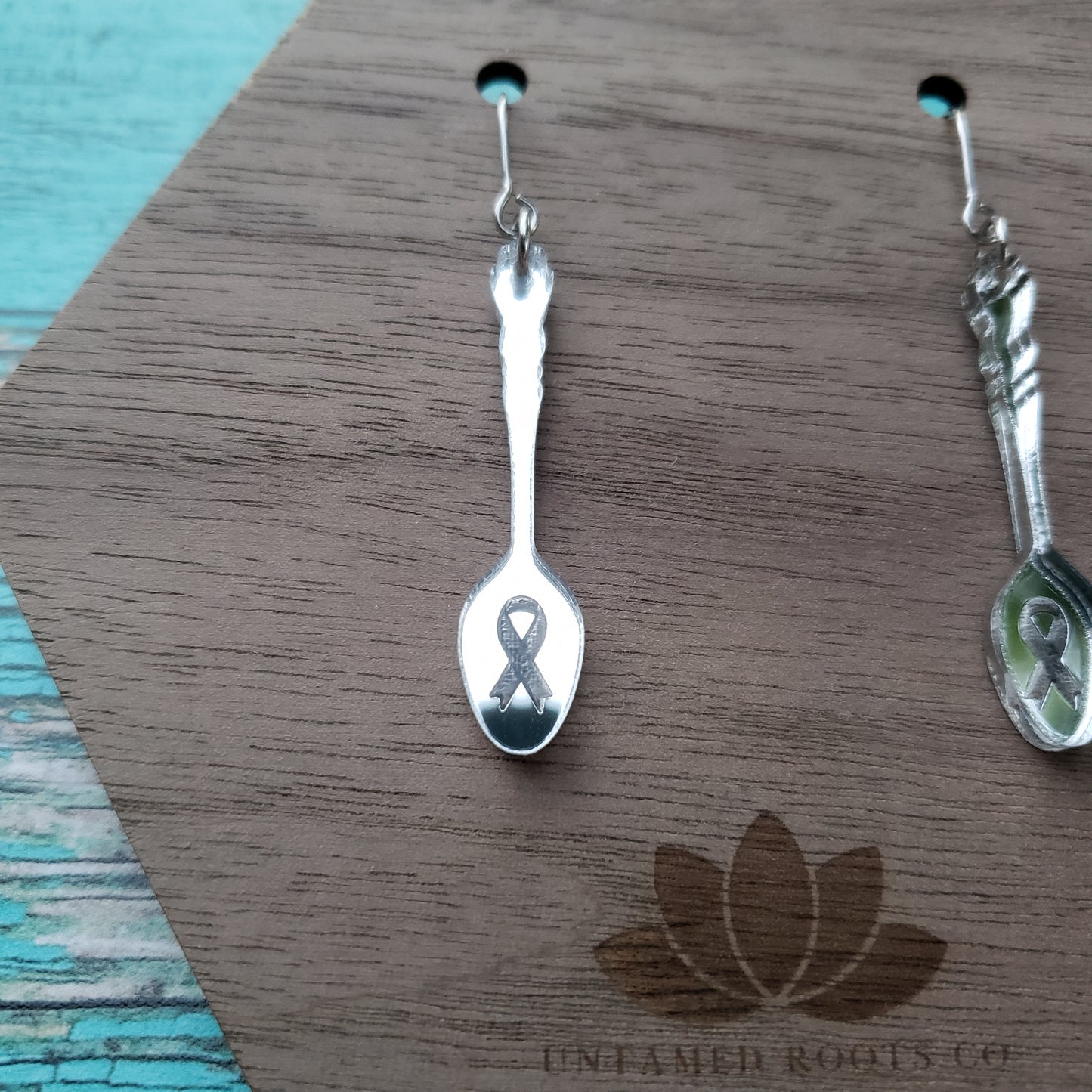 Close up of silver spoon earrings on stainless steel earring wires with ribbon engraving