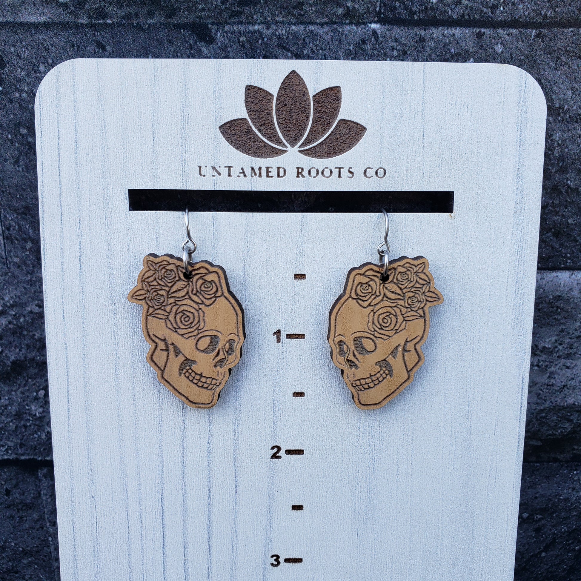 Skull and Roses dangle earrings on wood