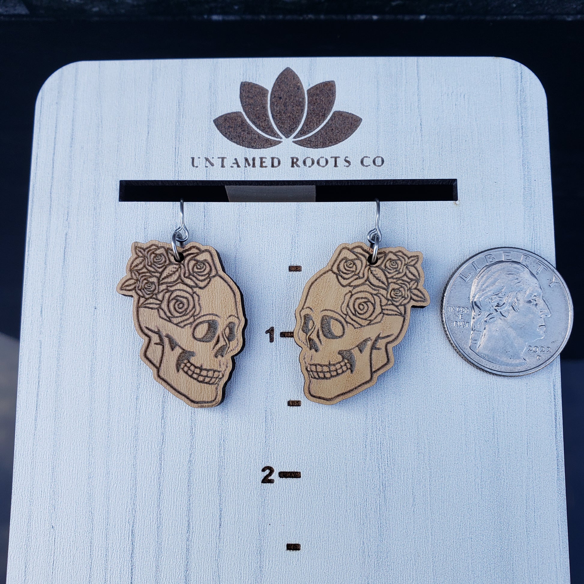 Skull and Roses dangle earrings on wood