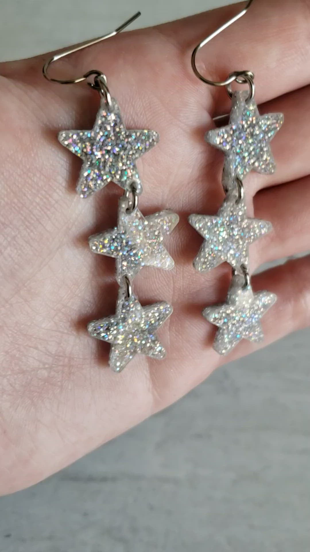 Video of silver holographic star dangle earrings to show effect