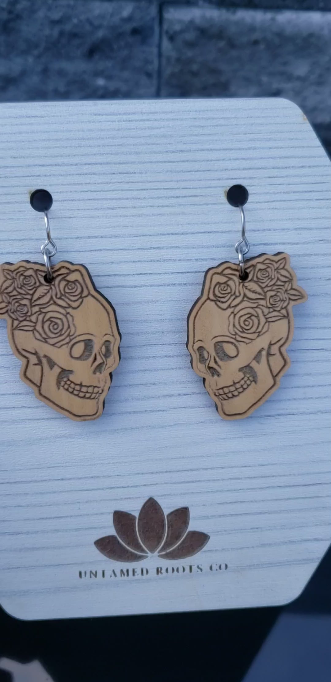 Skull and Roses dangle earrings on wood